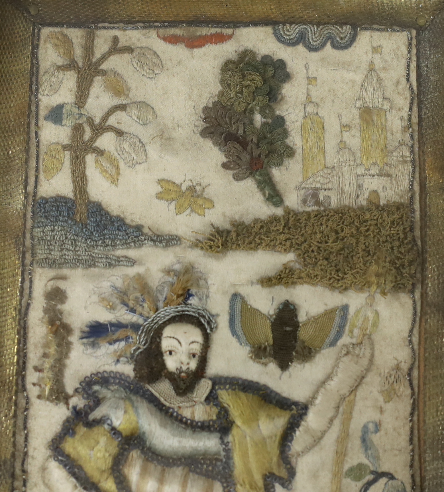 A framed 17th century stumpwork embroidery panel, embroidered with a central figure of a nobleman or king, possibly Henry VIII, holding a staff, wearing a cloth of gold with his dog in the grounds of a castle (possibly N